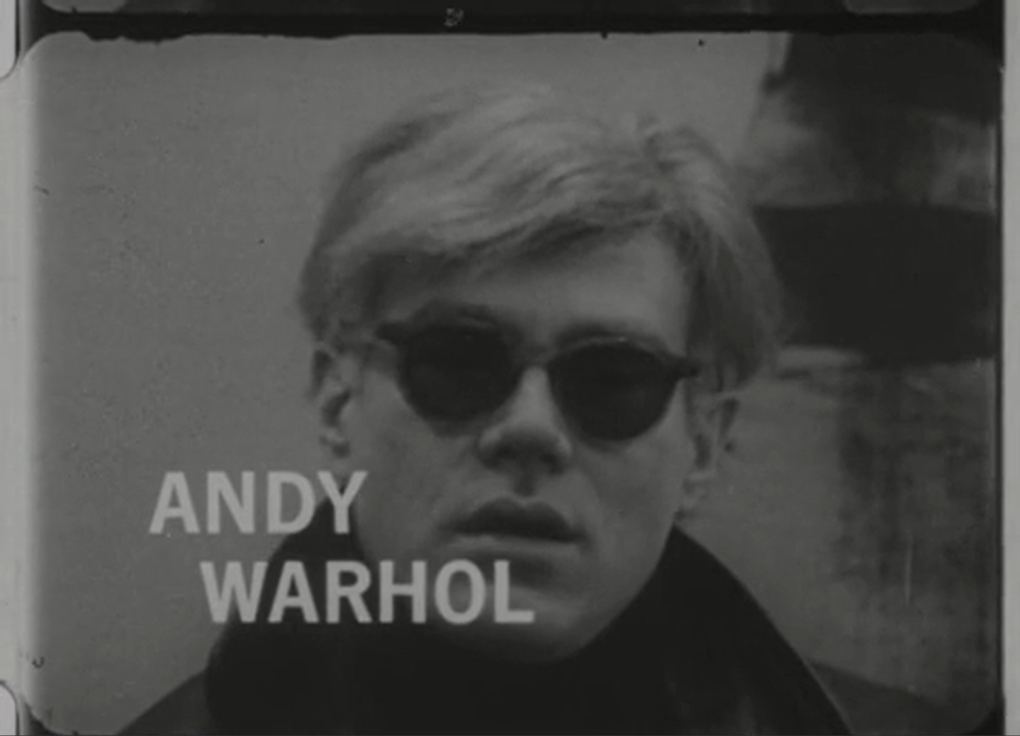 Black and white photo of Andy Warhol, with an overlaid title card reading "Andy Warhol."