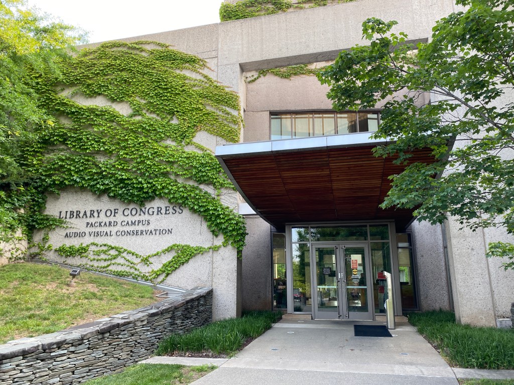 The concrete and ivy-covered entrance to the Library of Congress' Packard Campus for Audio Visual Conservation, which is etched into the left side of the building. 